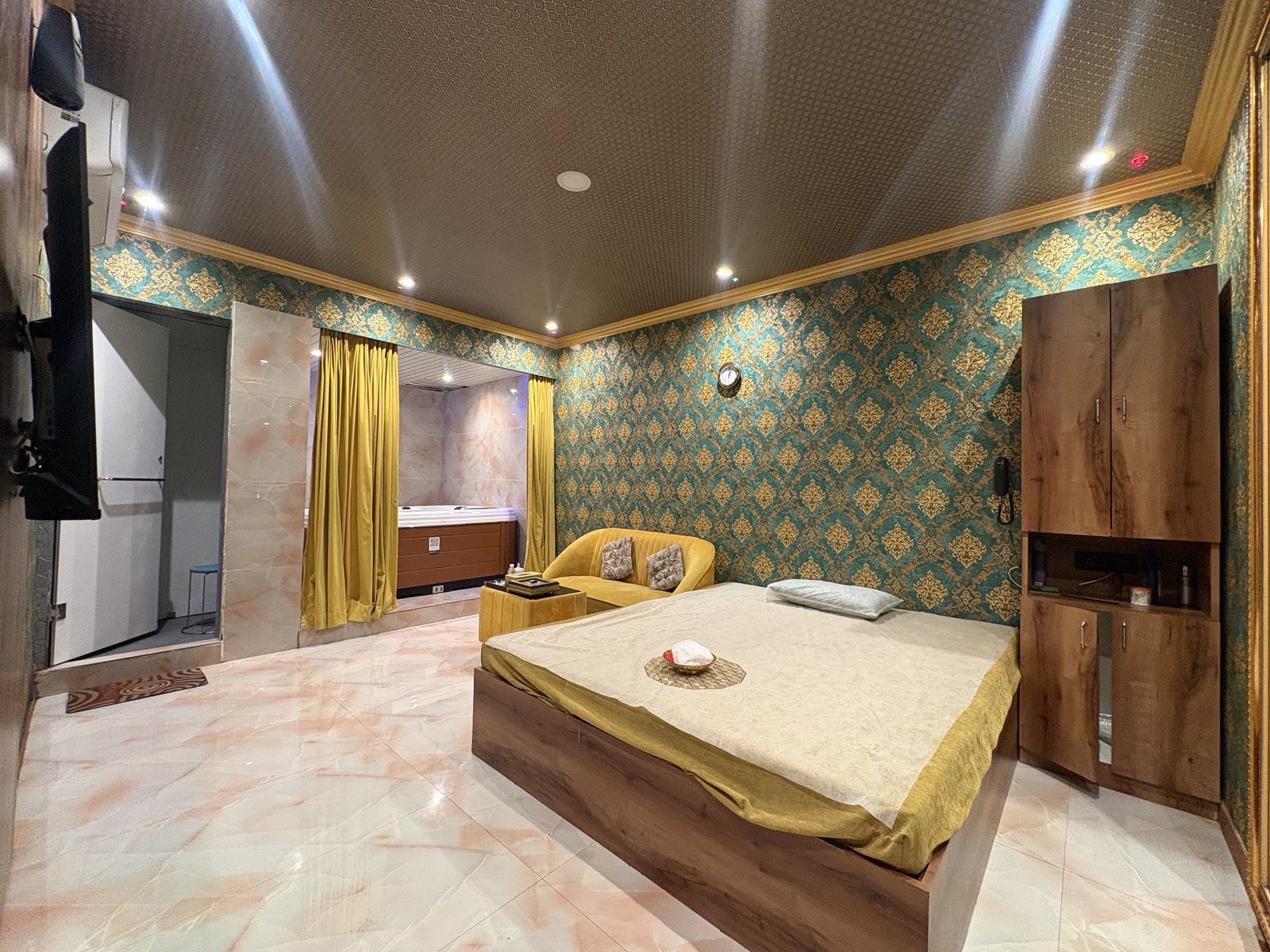 Treatment suite with massage bed, sofa, and Jacuzzi alcove