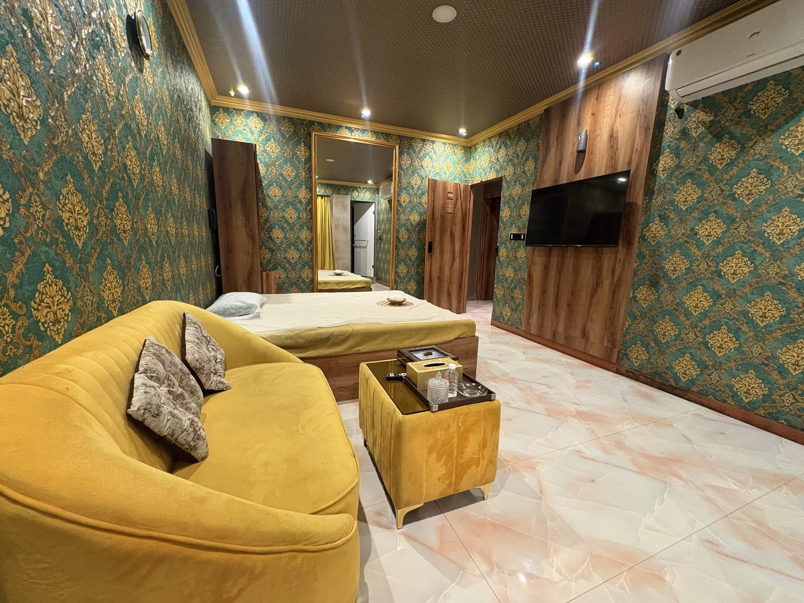 Lounge and massage bed in a teal and gold suite