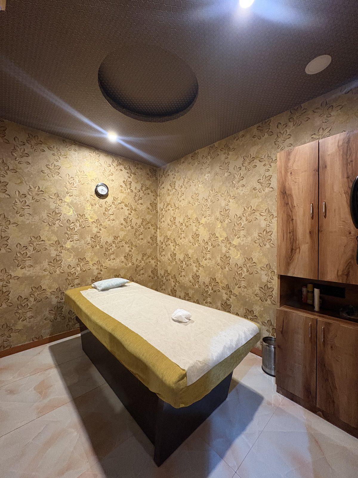 Private treatment room with a prepared massage bed